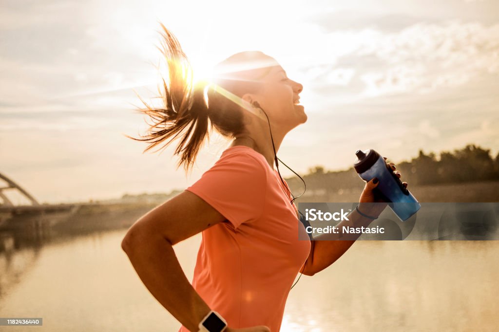 Joven corriendo contra el sol de la mañana - Foto de stock de Correr libre de derechos