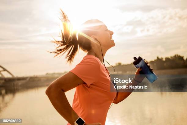 Joven Corriendo Contra El Sol De La Mañana Foto de stock y más banco de imágenes de Correr - Correr, Ejercicio físico, Mujeres