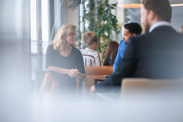 istock Business People Sharing Ideas in Corporate Office Lobby 1182436521