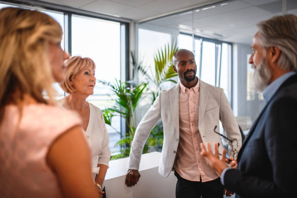 istock Mature Caucasian Businessman Conversing with Colleagues 1182436525