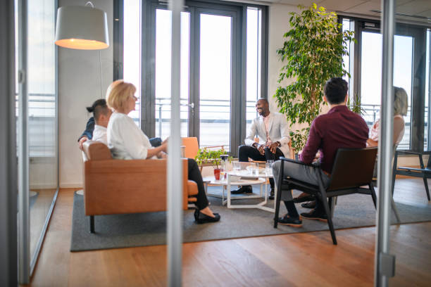 istock Smiling Business People Relaxing in Office Lobby 1182436596