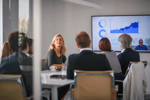 Photo of Businesswoman Listening to Associate During Video Conference