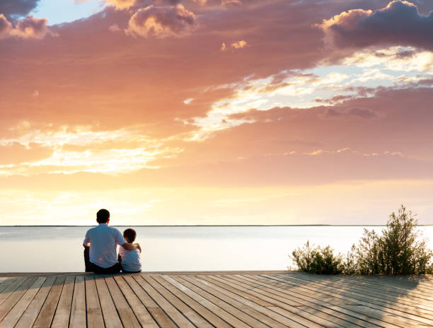 istock Father with his son enjoying lake view 1182436640