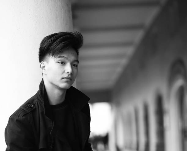 istock Black White photo of Asian young man outdoors posing 1182437761