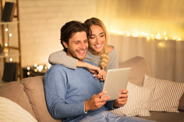 Happy spouses ordering Christmas gifts on tablet