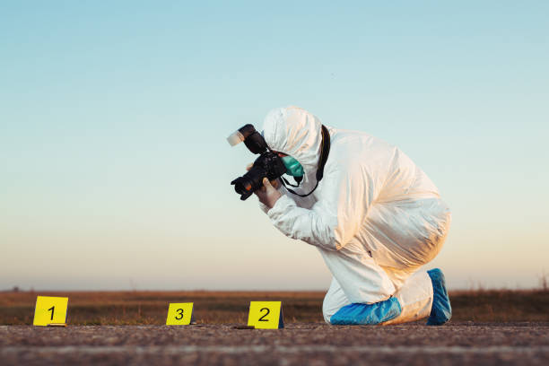 istock Detective studying a crime scene taking photographs. 1182438339