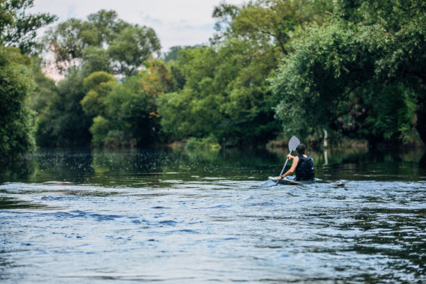 istock Kayaker lady paddling in river 1182438555