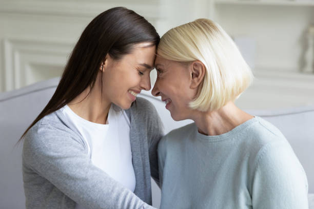 istock Happy young daughter touching foreheads with middle aged smiling mommy. 1182440340