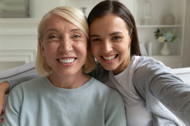 szczęśliwa dorosła córka robi selfie z uśmiechniętą matką. - happy kid audio zdjęcia i obrazy z banku zdjęć