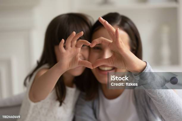 Happy Young Mother With Little Daughter Making Focused Heart Sign Stock Photo - Download Image Now