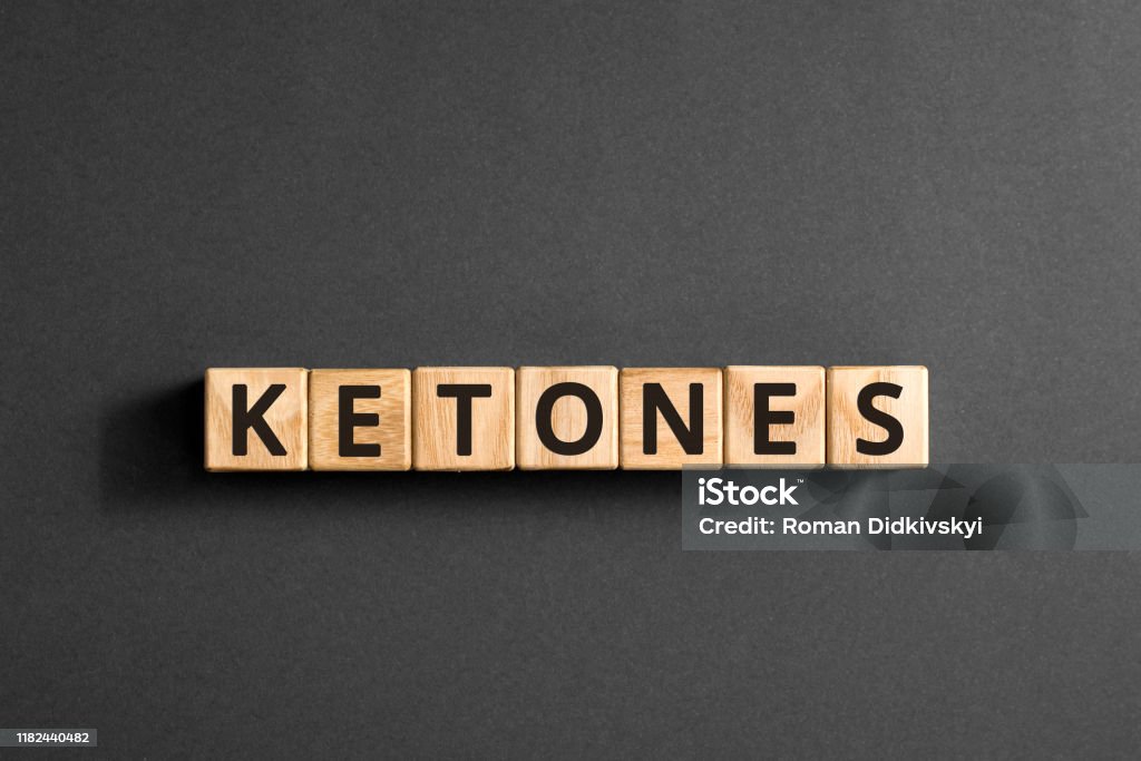 Ketones - word from wooden blocks with letters Ketones - word from wooden blocks with letters, chemical compound produced in the body urine burns fat ketones concept,  top view on grey background Ketogenic Diet Stock Photo
