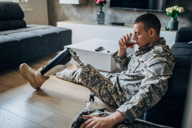 istock Disabled US soldier drinking whiskey alone 1182440592