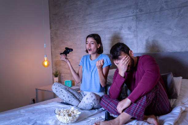 istock Couple playing video games in bed 1182441668