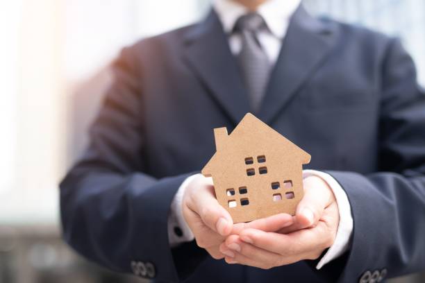 istock House model in home insurance property agent ‘s hand. 1182443964