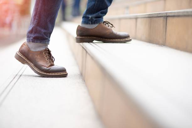 istock Image of a man walking up the stairs.successful 1182445115