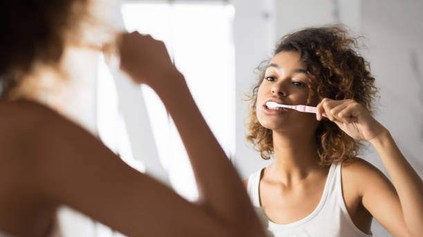 afro woman brushing teeth in bathroom, panorama - hairstyle crest imagens e fotografias de stock