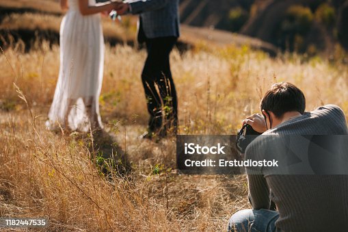 istock wedding photographer takes pictures of the bride and groom 1182447535