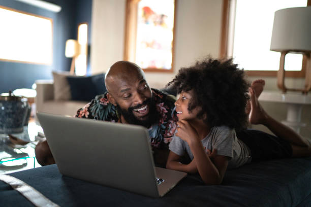 un padre single che wacthing film su un laptop con sua figlia - computer child family laptop foto e immagini stock