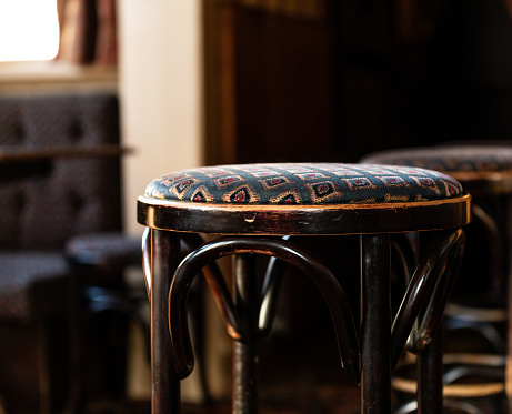 Tight shot of bar stool in traditional English pub with moody colours