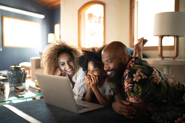 famiglia felice che guarda il film su un laptop - popolo di discendenza africana immagine foto e immagini stock