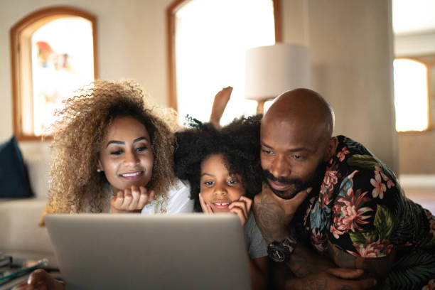 happy family watching movie on a laptop - lying down women laptop freedom imagens e fotografias de stock
