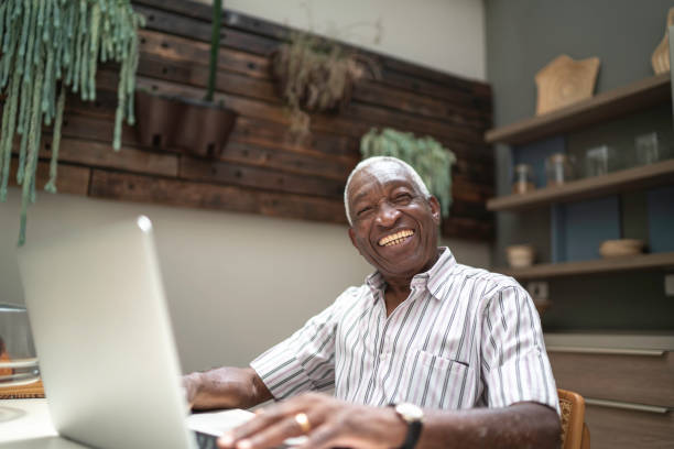 istock Portrait of a senior man using laptop in the kitchen table 1182452077