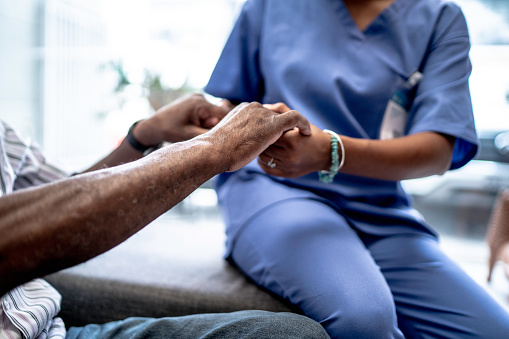 Enfermera sosteniendo las manos del paciente photo