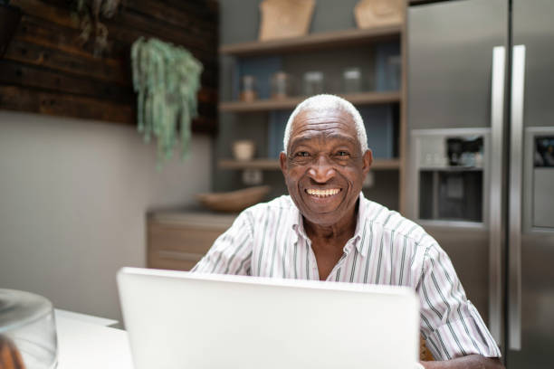 istock Portrait of a senior man using laptop in the kitchen table 1182452096