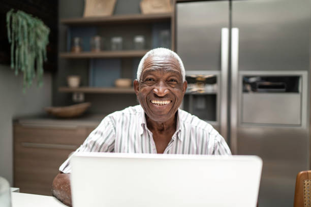 istock Portrait of a senior man using laptop in the kitchen table 1182452112