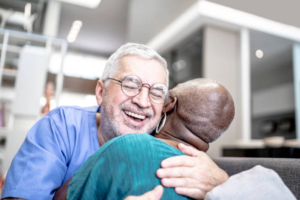 Male nurse embracing a patient at home