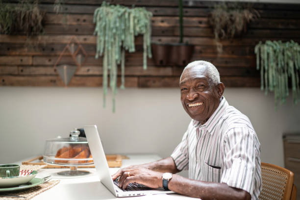 istock Portrait of a senior man using laptop in the kitchen table 1182452221