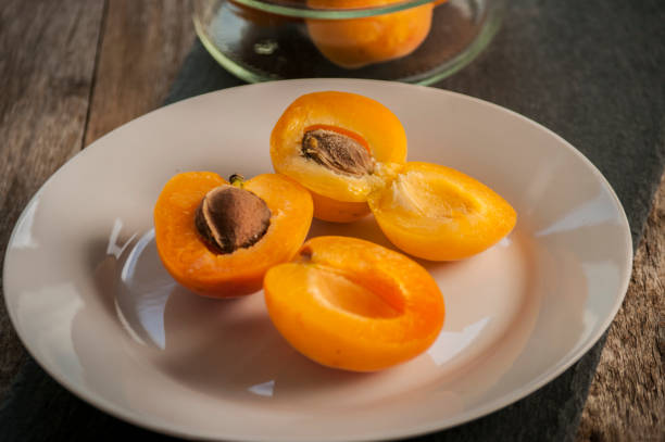 istock Sliced apricots isolated on black background 1182452283