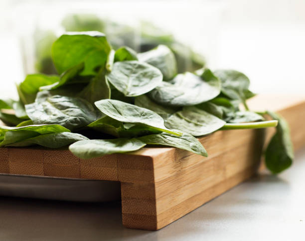 Baby spinach leaf on the kitchen wooden board Baby spinach leaf on the kitchen wooden board spinazie stock pictures, royalty-free photos & images