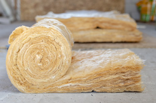 La lana de roca mineral tirada en el suelo del ático dentro de la casa en construcción photo