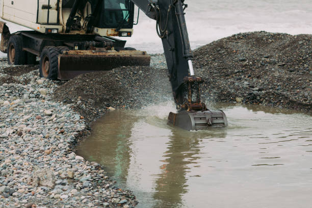 istock Heavy black excavator working on the beach 1182458460