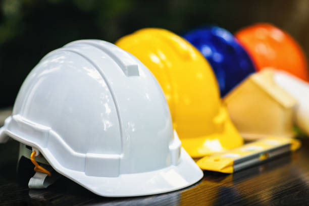 istock White and colored helmets that have different duties for the safety program of workers in the position of engineers or workers on the table. 1182458780