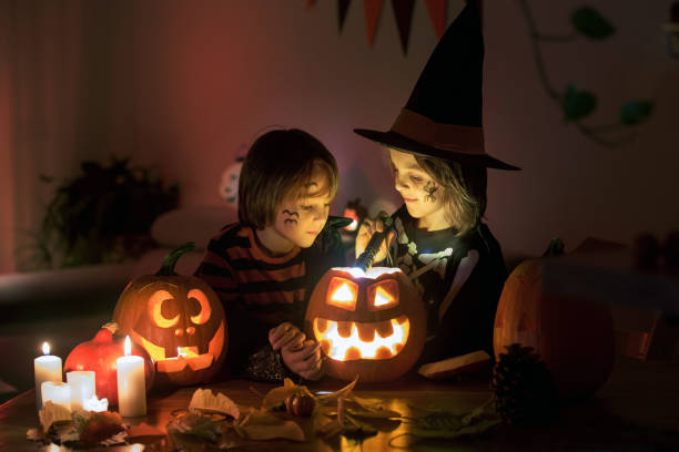 children, boy brothers, playing with carved pumpkin at home on halloween - preschooler autumn beautiful blond hair imagens e fotografias de stock