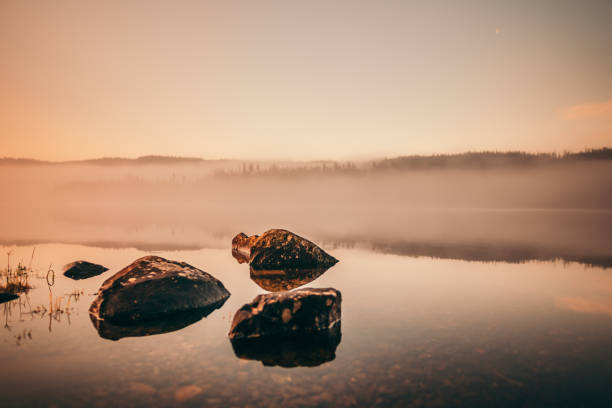 istock Rocks on a misty lake 1182460516