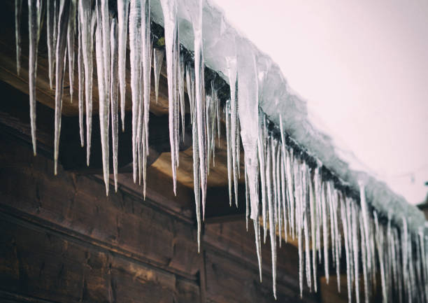 istock Icicles hanging from the old, rustic house 1182462020
