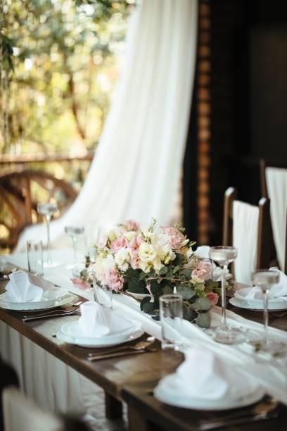 istock Dining table with floral centerpiece at wedding reception. 1182462263