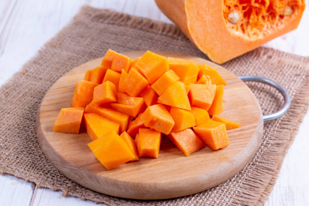 istock Cubes of pumpkin on cutting board 1182463094