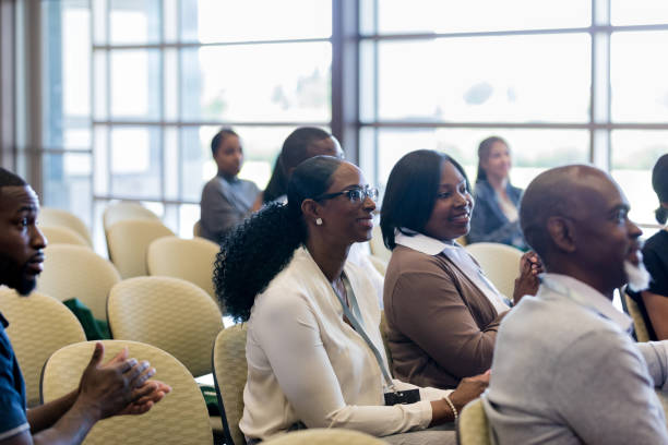 istock Smiling women listen during conference 1182464441