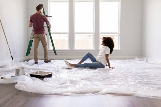 istock Pregnant woman relaxes while husband paints room 1182464642