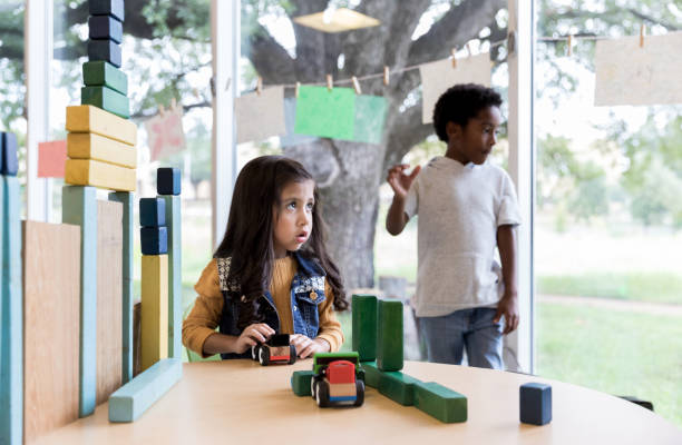 istock Young girl and boy look at unseen person during playtime 1182464708