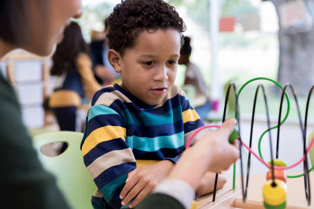istock Unrecognizable teacher shows young student how to move beads 1182464725