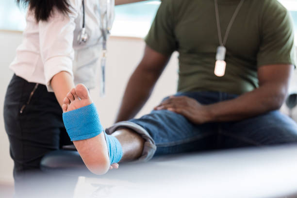 istock Close up unrecognizable veteran's foot as therapist guides stretch 1182464790