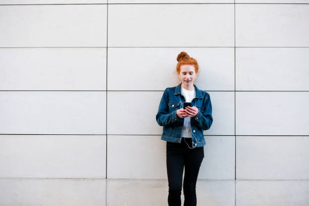 istock Young woman focuses on smart phone while waiting 1182465024