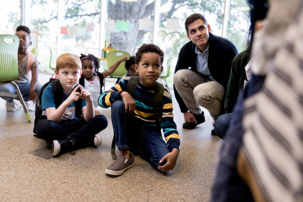 istock Attentive kindergarten students listen to teacher 1182465165