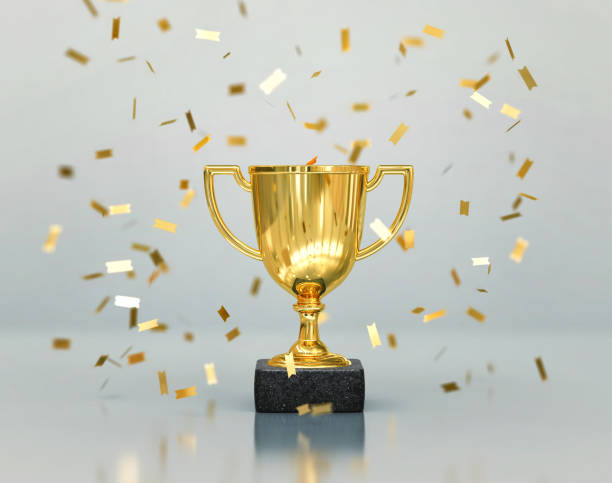 Gold winners trophy, champion cup with falling confetti Gold winners trophy, champion cup with falling confetti on gray background. 3D rendering championship stock pictures, royalty-free photos & images
