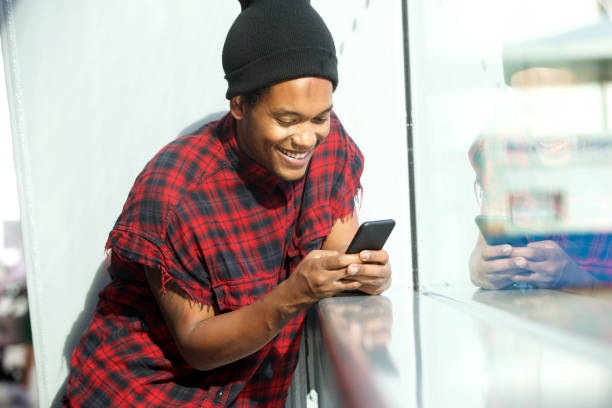 istock smiling african american man looking at mobile phone 1182465982